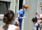 Personal de salud atiende a personas que acuden a realizarse una prueba para detectar la covid-19 en el Hospital Pedro Elizalde, hoy, en Buenos Aires (Argentina). Argentina vive una "tercera ola" de la pandemia marcada por cifras récord de contagios de la variante ómicron, una situación que está colapsando los principales centros de testeo y los sistemas de atención primaria, mientras el Gobierno opta por no imponer restricciones que frustren las vacaciones de verano.