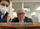 Ponente. Un empleado de la Asamblea asiste a Marcos Molina, presidente de la Comisión de Salud, para instalarlo correctamente en el Zoom.