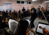 Un maestro de música dirige un concierto de "El Sistema" para invitados extranjeros.