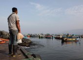 Un pescadores artesanales observa los botes en la bahía de Ancón, el 25 de enero de 2022 en Lima (Perú). Cada mañana, durante cientos de años, el pueblo pesquero de Ancón se ha llenado de embarcaciones, redes y peces, pero ahora solo luce la desesperación y el enfado de pescadores que casi lo han perdido todo tras el gran desastre ambiental causado por el derrame de petróleo en el norte de Lima. EFE/ Juan Ponce