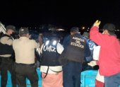 Policías y pescadores desembarcan el cuerpo que fue hallado en altamar, entre las redes de un pescador.