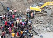Cientos de personas y maquinaria pesada extraen oro durante el día.