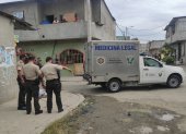 Policías rodean el cuerpo de la víctima que ha sido cubierto con una sábana.