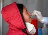 Fotografía de archivo de una mujer mientras se realiza una prueba PCR para detectar covid-19 en Quito (Ecuador).