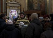 Uno de los sacerdotes de la Catedral Svyato-Uspensky, de la Iglesia Ortodoxa Ucraniana, ofrece una cruz a los fieles para que la besen durante el oficio. EFE/Manuel Bruque