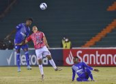 Robin Ramírez (c) de Independiente disputa el balón con Jackson Rodríguez de Emelec.