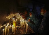 Personas encienden velas en la madrugada de hoy tras realizar la "Caminata de la Fe", desde la ciudad de Ambato hacia Baños de Agua Santa, en la provincia de Tungurahua (Ecuador).