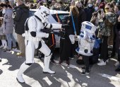 Un soldado de asalto imperial de la saga cinematográfica Star Wars se acerca a dos niños disfrazados mientras participan en el desfile del Galaxy Day, el domingo por una calle de Madrid.