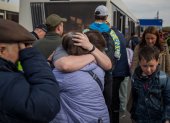 Refugiados se abrazan hoy martes 3 de mayo de 2022 tras llegar al estacionamiento de un centro comercial en Zaporiyia (Ucrania). La viceprimera ministra de Ucrania, Iryna Vereshchuk, anunció este martes el éxito de la "primera parte" de la operación para rescatar de la acería de Azovstal a un convoy con cerca de 150 mujeres, ancianos y niños que, según dijo, llegarán pronto a Zaporiyia. EFE/ MIGUEL GUTIÈRREZ