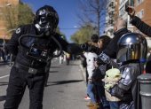 Un piloto del cuerpo imperial de cazas estelares TIE de la saga Star Wars (i) saluda a un pequeño mandaloriano (d) durante el desfile del Galaxy Day por una calle de Madrid.