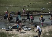 Un grupo de venezolanos atraviesan un riachuelo en la frontera entre Ecuador y Perú.