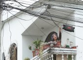 Marisol Paredes, quien reside en la manzana 207 de Guayacanes, muestra a EXPRESO la hilera de cables que cruzan el balcón de  su casa. Muchos de ellos no tienen ninguna función, pero nadie los ha ido a retirar.