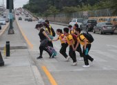 Padres y estudiantes del colegio Teniente Hugo Ortiz se lanzan a la avenida Teodoro Alvarado Oleas para ir de un carril a otro, sin tomar las debidas medidas.