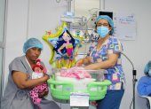 Fotografía cedida por el Hospital General Teófilo Dávila que muestra a Yanelys (i) mientras sostiene a su hija Milagros junto a la pediatra Catalina Campoverde, el 7 de julio de 2022, dentro de ese centro médico en Machala, provincia de El Oro (Ecuador).