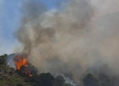Un helicóptero del servicio de bomberos trabaja en el incendio declarado en la sierra de Mijas, Málaga, este sábado.