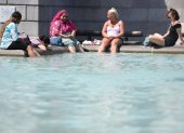 La gente se refresca en la fuente de Trafalgar Square, Londres.