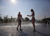 Personas se refrescan en una fuente ante las temperaturas registradas durante una ola de calor