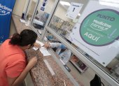 Alexandra Marín recibe una explicación sobre el sistema en la farmacia del hospital Monte Sinaí, donde también se sigue entregando medicinas a los pacientes.