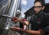 El gerente de producción de Sinners Micro Cervecería, Andrés Bermeo, sirve una muestra de la cerveza el 19 de agosto de 2022 en Quito (Ecuador).