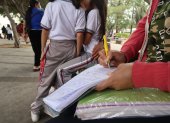 Unos padres acuden a los planteles para realizar la contribución, mientras que otros no pueden hacerlo.