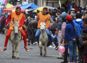 Varias personas con sus burros participan en una carrera, hoy, en Salcedo (Ecuador).