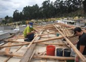 Reparación. Los hijos de una de las afectadas por el temporal reparan los techos.