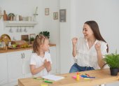 Mom and daughter are happy to finish their homework in the kitchen. Home life. Real joy