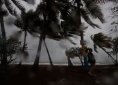 Una persona camina entre la lluvia y los fuertes vientos debido al paso de una tormenta por Puerto Rico, en una fotografía de archivo