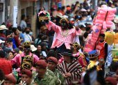 El personaje "Mama Negra" (c) recorre las calles en el tradicional rito mercedario en la cuidad de Latacunga (Ecuador).