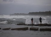 Dos personas pescan en la playa hoy, mientras el país se prepara para el paso en las próximas horas del huracán Fiona, en Nagua (República Dominicana).