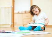 calm two year child sketching on paper in home interior