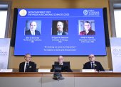 Miembros de la Real Academia anuncian a los ganadores del Premio Nobel de Economía 2022, cuyos rostros y nombres aparecen en la pantalla, este 10 de octubre e Estocolmo.