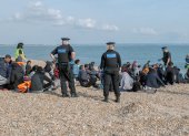 Oficiales de policía y de la institución de salvavidas junto a migrantes que fueron rescatados en el Canal de la Mancha, en Dungeness, Reino Unido, el 22 de septiembre.