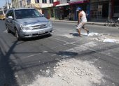 Andrés Romero coloca material de construcción en los huecos que se han formado en la avenida Laurice Anton. Una labor que realiza cada cuatro días.