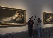 Captura de video del momento en el que dos activistas de la organización Futuro Vegetal se han pegado a los marcos de los cuadros de "La maja vestida" y "La maja desnuda" del Museo del Prado y han escrito en la pared "+1.5°" en referencia al anuncio de la ONU de la imposibilidad de cumplimiento del Acuerdo de París. EFE/Futuro Vegetal -