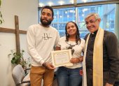 Los migrantes venezolanos Yonaiker Brujo y Nathalie Quintana muestran el certificado de matrimonio junto al sacerdote luterano, el padre Fabián Arias, en la iglesia San Pedro en Manhattan, Nueva York.