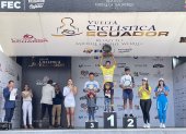 El ciclista colombiano Robinson Chalapud (c) con el maillot amarillo y el trofeo como campeón de la Vuelta al Ecuador.
