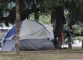 Una mujer en situación de calle cuelga su ropa en un parque público en el que acampa, hoy, en Santiago (Chile). El 32,1 % de la población total de la región, lo que equivale a 201 millones de personas, vivirá en situación de pobreza para finales de este año, de los que 82 millones (13,1 %) se encontrarán en pobreza extrema, informó este jueves la Comisión Económica para América Latina y el Caribe (Cepal). EFE/ Elvis González