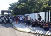 Migrantes hacen fila para intentar resolver su situación migratoria a las afueras del módulo de atención provisional ubicado en el parque ecológico, hoy, en Tapachula (México).