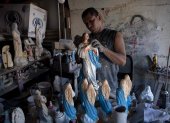 Managua. Un hombre exhibe las esculturas de la Virgen en las que trabaja en estos días.