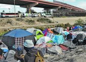 MEX917. CIUDAD JUÁREZ (MÉXICO), 24/11/2022.- Migrantes reciben hoy alimentos en un campamento junto al Río Bravo con motivo del día de Acción de Gracias, en Ciudad Juárez, estado de Chihuahua (México). Migrantes del norte de México apoyaron a otro grupo de indocumentados en situación vulnerable proveyéndolos de alimento con motivo del Día de Acción de Gracias. Más de 3.000 platillos fueron elaborados con un esfuerzo de más de dos días seguidos de preparación por parte de voluntarios que buscan llevar un mensaje de alegría y fe en esta festividad. EFE/Luis Torres