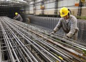 Fábrica.- Los trabajadores construyen columnas de barras de refuerzo en una planta.