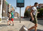 Sevilla. Varias personas pasan ante el termómetro próximo a la estación de autobuses de Plaza de Armas de esta ciudad española en un día en que las temperaturas máximas superan los 40 grados.