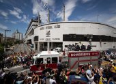 Un camión de bomberos que transporta el féretro con el cuerpo de la leyenda del fútbol Edson Arantes do Nascimento "Pelé encabeza hoy el cortejo fúnebre que recorrerá algunas calles de la ciudad, rodeado de miles de aficionados, en dirección al cementerio donde será enterrado el tres veces campeón mundial, en Santos (Brasil).
