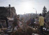 -Voluntarios limpian escombros en el sitio de un ataque con misiles rusos