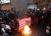 Personas queman una bandera de Estados Unidos durante una protesta frente a la embajada de Francia en Teherán /EFE