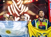 El piloto Sebastián Guayasamín (d) y su celebración con la bandera ecuatoriana tras concluir el rally Dakar.