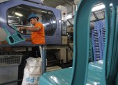Industria. Una persona en planta que elabora sillas plásticas.