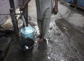 Un hombre llena unos cubos de agua en una fuente en un mercado en Amritsar (India), en una fotografía de archivo.