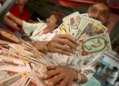 Un filipino, echador de cartas del Tarot para adivinar el destino de los transeúntes, en Manila. La cartomancia es una de las mancias adivinatorias.